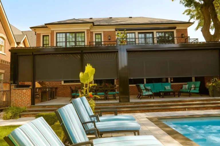 Louvered aluminum pergola on a large brick home, enclosed with dark motorized retractable screens over a poolside patio
