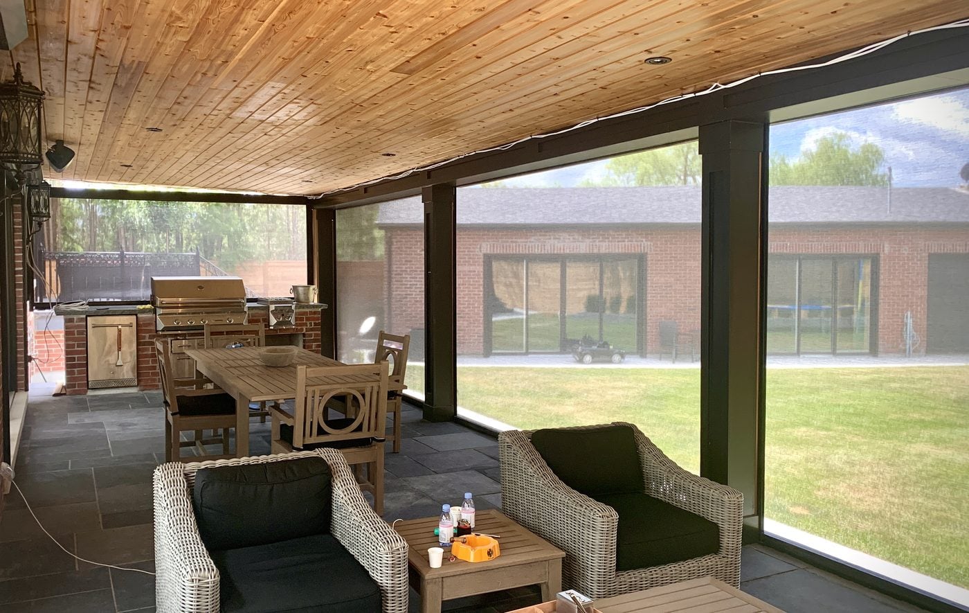 Covered patio with retractable mesh screens enclosing the seating area
