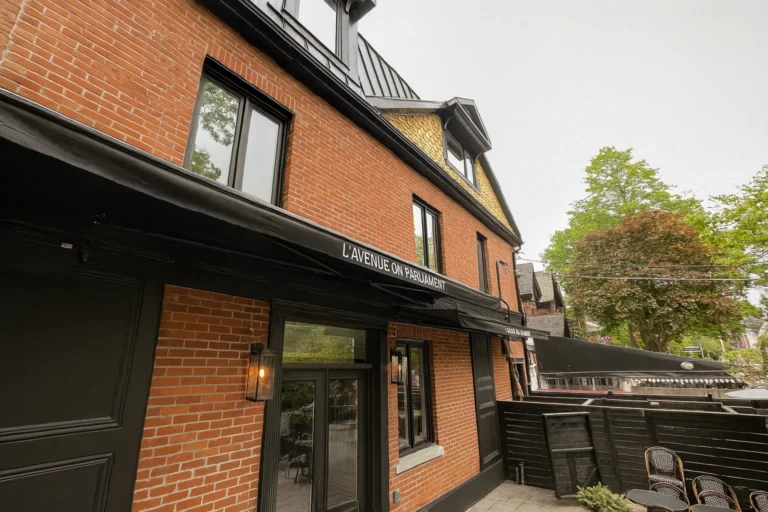 Black retractable awning extended along the brick facade of a restaurant patio
