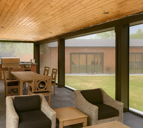 Retractable mesh screens enclosing a covered patio with a wood-plank ceiling, dining and lounge seating inside